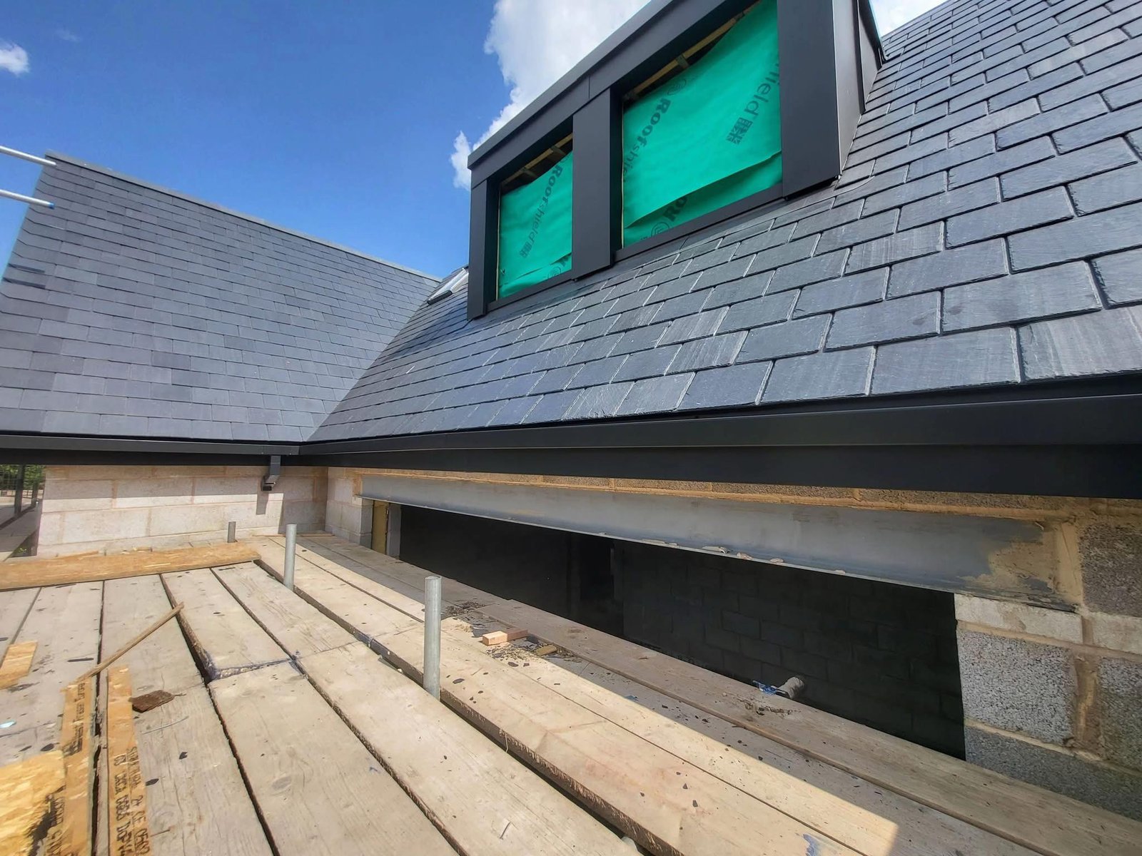 Close-up of expertly installed natural slate roof valley with precisely aligned slate tiles and lead-free detailing for long-term weather protection.